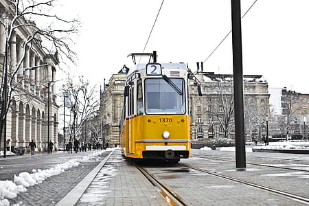 A yellow tram on a snowy road during the day time thumbnail