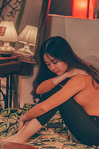 Woman Sitting on Bed Inside Room thumbnail