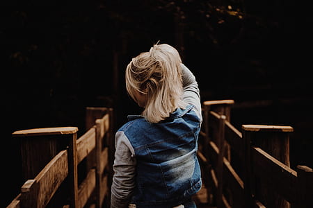 woman holding her hair on wooden bridge thumbnail