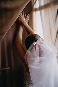 woman wearing white veil leaning on wall thumbnail