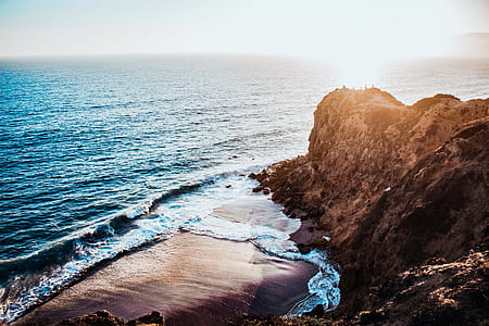 landscape photo of brown cliff near body of water thumbnail
