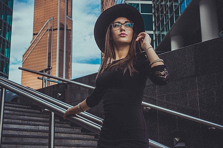 woman standing on stairs while holding hair thumbnail