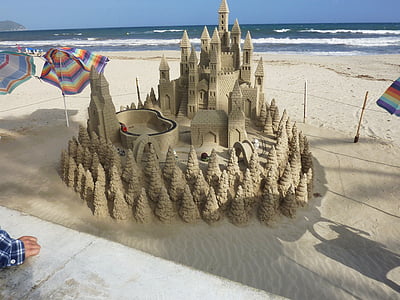 brown sand castle near body of water thumbnail