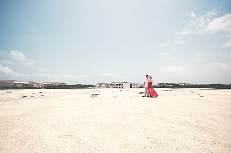 man and woman standing on sands thumbnail