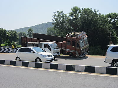orange dump truck parked beside road thumbnail