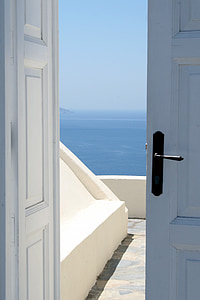 slightly open white door overlooking body of water thumbnail