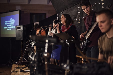 woman standing while singing on stage thumbnail