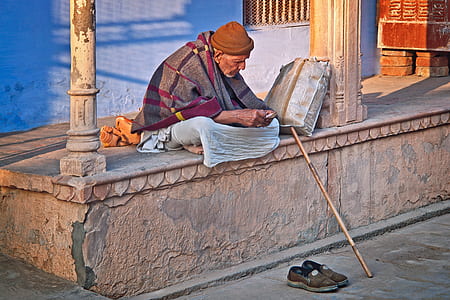 man covered by grey and black blanket thumbnail