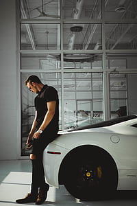 man sitting on Ferrari car inside glass room thumbnail