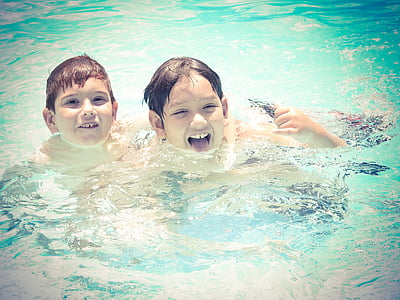 two boys on body of water photo during daytime thumbnail