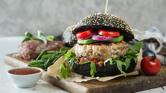 black hamburger beside tomato thumbnail