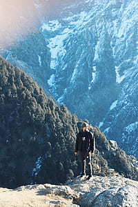 man standing on gray rock above a mountain thumbnail
