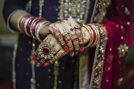 Woman Wearing Red And Gold Dress Holding Up Hands thumbnail