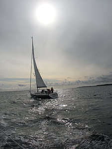 boat sailing on body of water under nimbus clouds thumbnail
