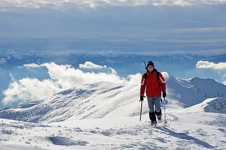 man walking on mountain covered with snow thumbnail