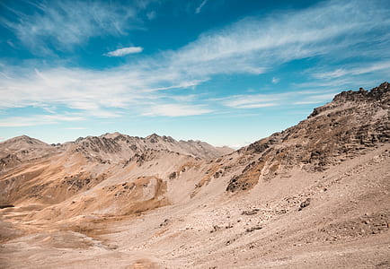 brown mountain under cloudy sky thumbnail