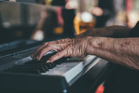 close up photo of person's hands playing black piano thumbnail