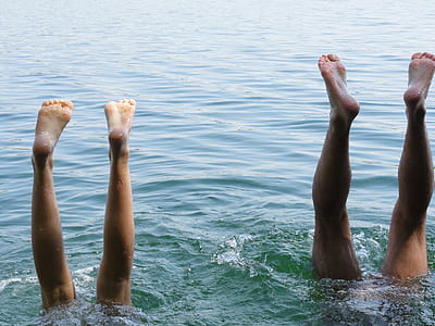 two person's feet on body of water thumbnail