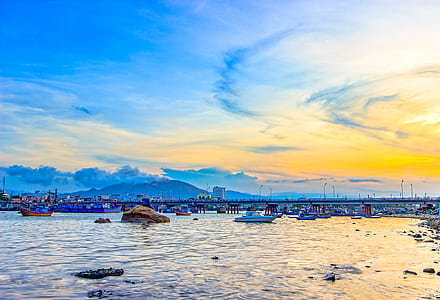 white boat near dock and bridge during golden hour thumbnail