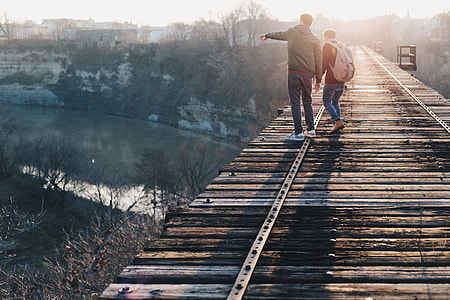 man and woman walking on brown bridge thumbnail