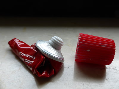 red toothpaste tube container with red plastic cap thumbnail