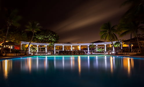 silhouette photo of swimming pool near cottages thumbnail