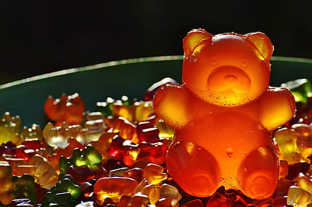 orange gummy bear candy on top of pile of smaller gummy bears thumbnail