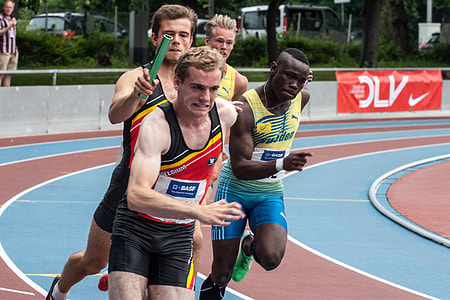 male athletes racing on track field during daytime thumbnail