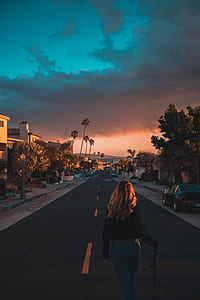 woman walking on road under sunset thumbnail