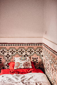 red and white throw pillows on top of bed thumbnail