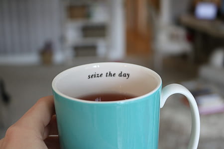 person holding white and teal ceramic mug thumbnail