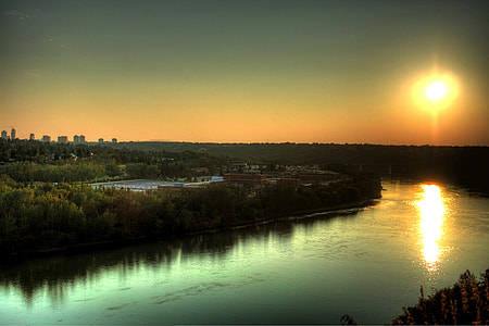 top view of body of water beside green trees during sunset thumbnail