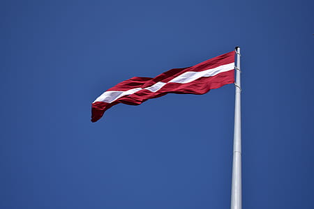 Red and White State Flag Waving Under Blue Sky at Daytime thumbnail