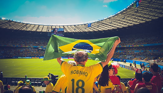 photo of man raising flag of Brazil on sports stadium thumbnail