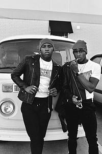 grayscale photography of two men standing beside Volkswagen T2 thumbnail