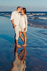 woman and man kissing near body of water during daytime thumbnail