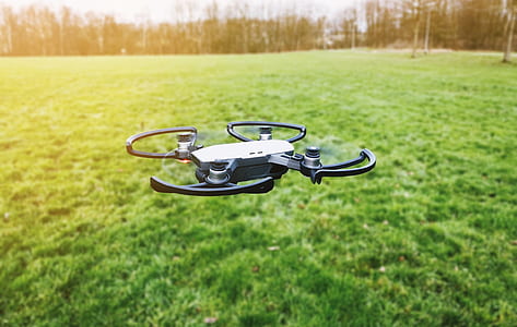 black and gray quadcopter drone flying above ground at daytime thumbnail
