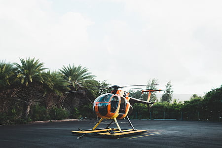 orange and black helicopter on land thumbnail