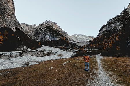 man standing in front of grey rocky mountains thumbnail