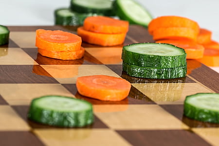 sliced cucumber and carrots on brown chess board thumbnail