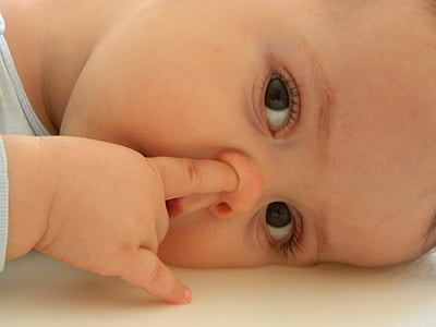 child wearing white top picking nose thumbnail