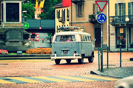white and blue Volkswagen T2 on road in front of beige concrete 2-storey house thumbnail
