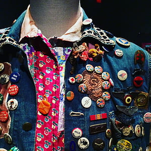 blue button-up top full of pin-back badges thumbnail
