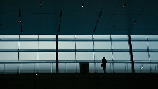 man standing near glass wall thumbnail