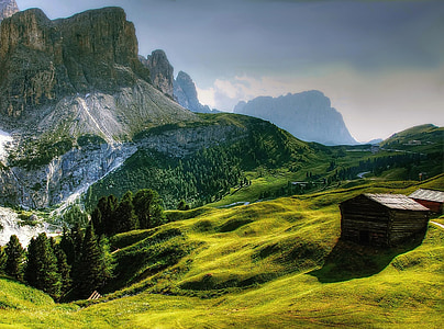landscape photo of shack on hill near mountains thumbnail