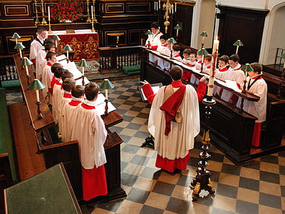 priest in the middle of group of children inside room thumbnail
