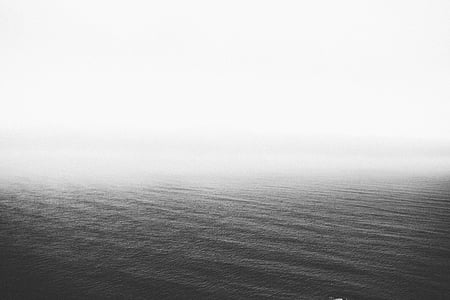 grayscale view of body of water surrounded by fog thumbnail