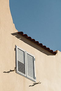white wooden louvered window surrounded with beige painted wall thumbnail
