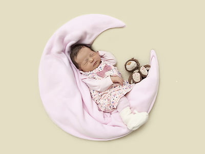 baby wearing pink cloth laying in pink textile thumbnail
