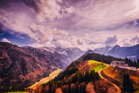 green trees and mountains under white clouds and blue sky during daytime thumbnail